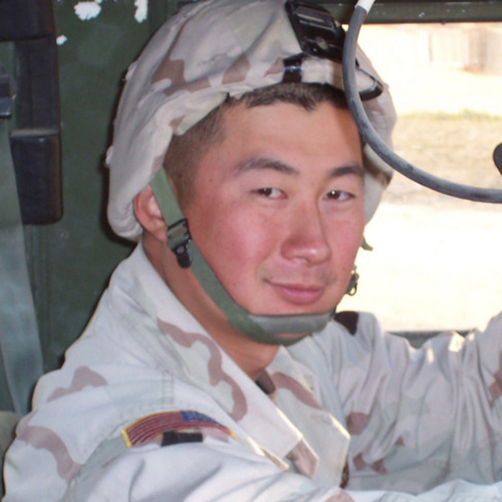 Portrait of Staff Sergeant Kyu Hyuk Chay in desert camouflage and helmet.